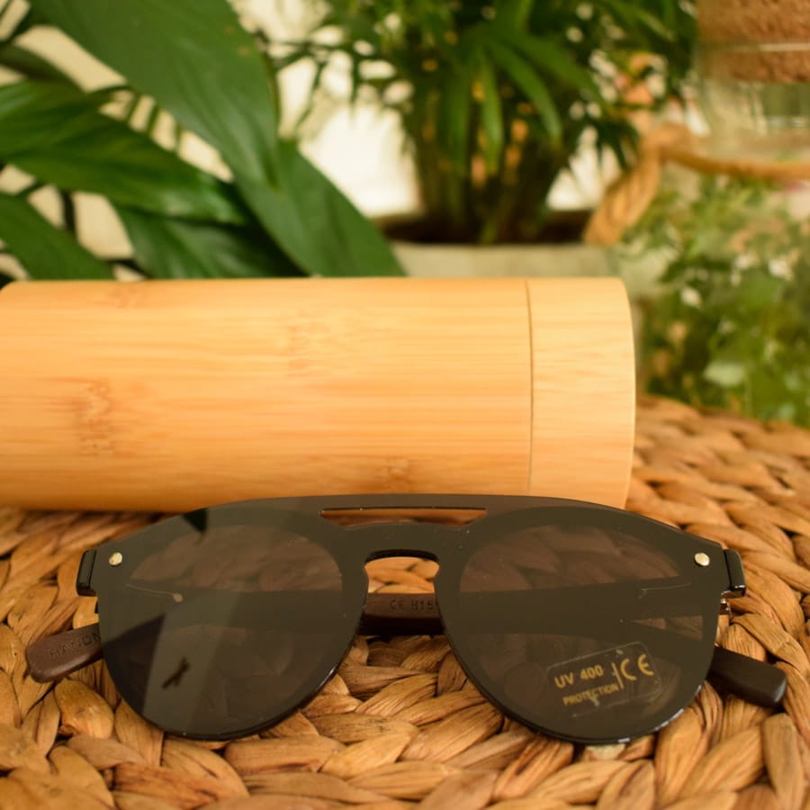 drewniane-czarne-okulary-przeciwsloneczne-na-stole-obok-rosliny